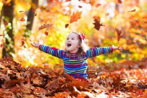 Girl Playing In Leaves